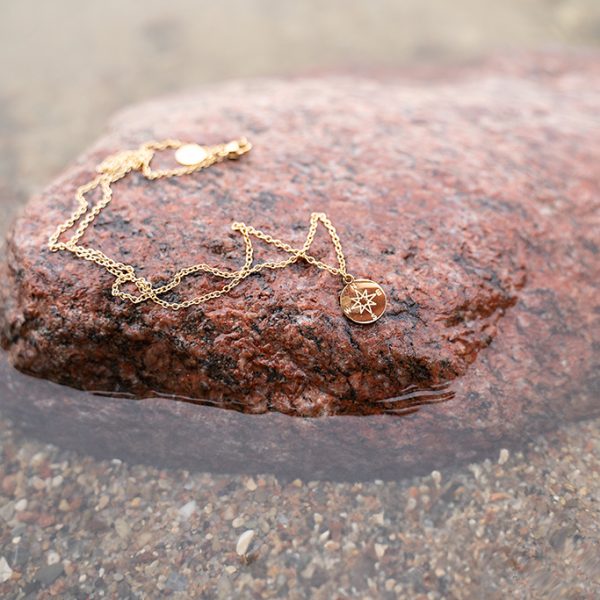 Goldene Halskette mit Sternanhänger auf einem Stein – Schmuck-Produktfotografie Neubrandenburg
